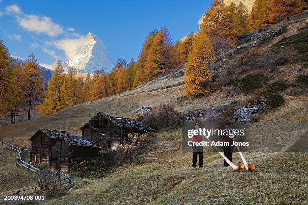 switzerland, zermatt, two alphorn players near matterhorn - zermatt stock-fotos und bilder