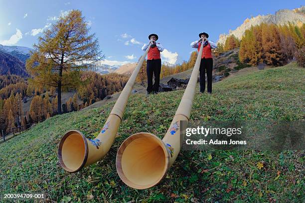 switzerland, zermatt, two alphorn players near matterhorn - blaasinstrument stockfoto's en -beelden