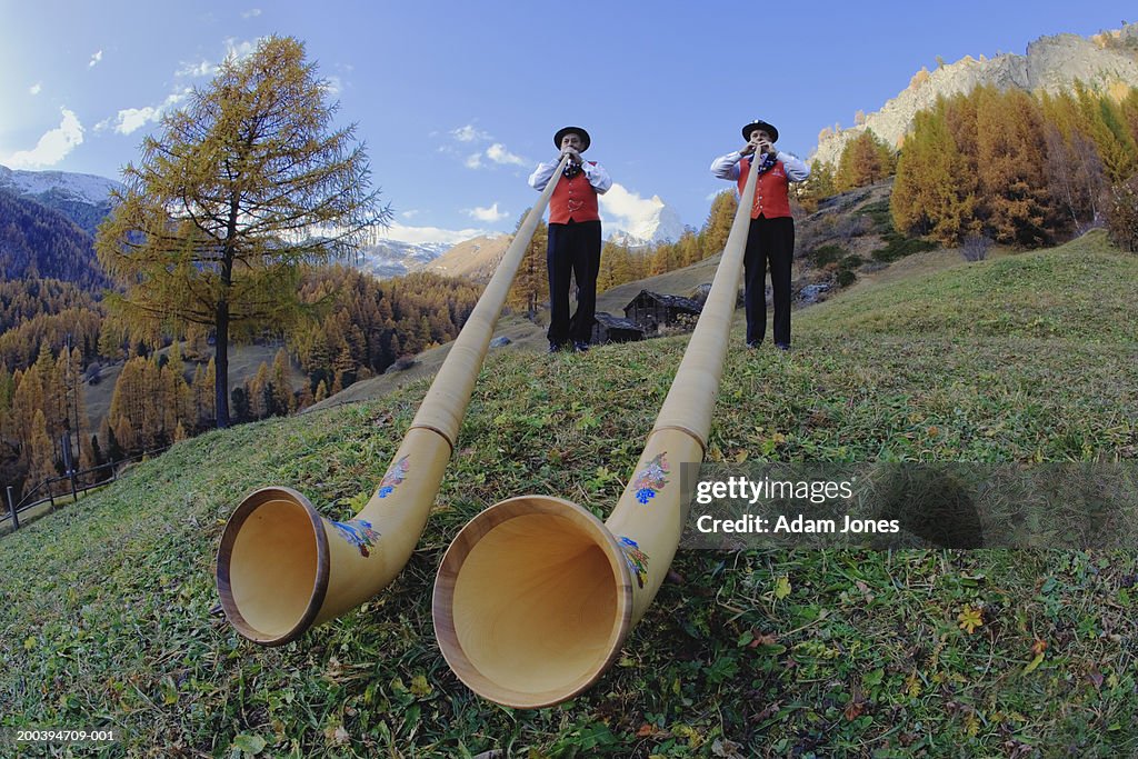 Switzerland, Zermatt, two alphorn players near Matterhorn