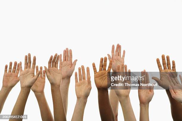 several people holding their hands in the air - braccia alzate foto e immagini stock