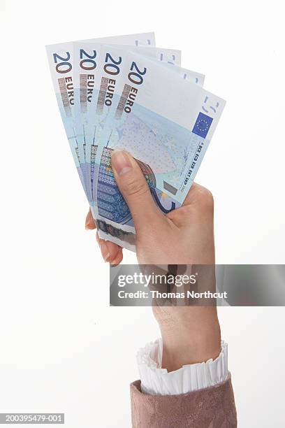 woman holding euro currency (focus on currency) - twenty euro note stock pictures, royalty-free photos & images