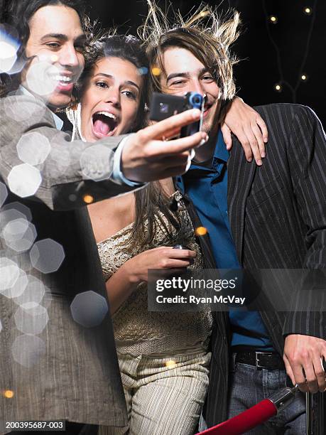 young man taking self portrait with young woman and man, behind rope - glamour selfie stock pictures, royalty-free photos & images