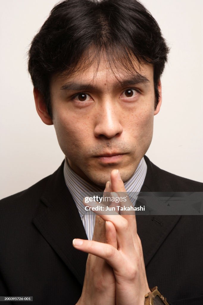 Businessman with hands clasped, close-up, portrait