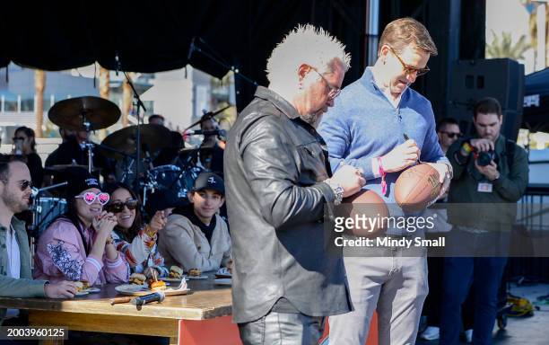 Guy Fieri and Eli Manning onstage at Guy Fieri's Flavortown Tailgate on February 11, 2024 in Las Vegas, Nevada.