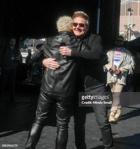 Guy Fieri and Gordon Ramsay embrace onstage at Guy Fieri's Flavortown Tailgate on February 11, 2024 in Las Vegas, Nevada.