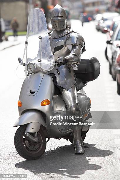 man wearing knight armour on moped - armoured fotografías e imágenes de stock