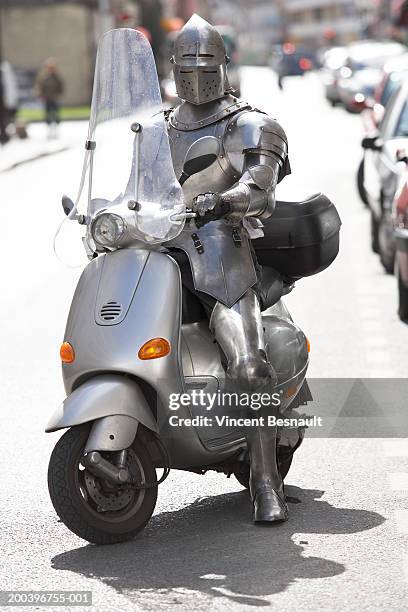 man wearing knight armour on moped - ridder stockfoto's en -beelden
