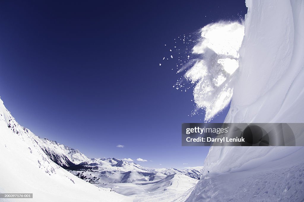 Shadow of snowboarder on snow cloud, jumping from cornice