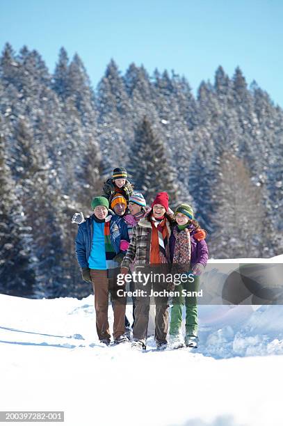 multi generational family walking through snow in winter landscape - grandfather child snow winter stockfoto's en -beelden