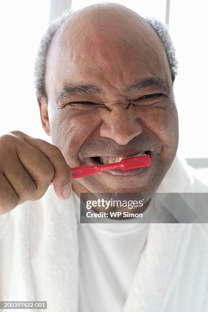 senior man brushing teeth, portrait, close-up - old man funny face black and white stock-fotos und bilder