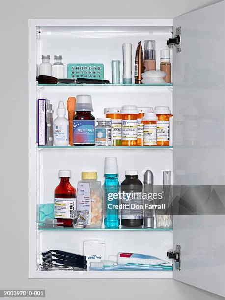 assorted medications and grooming products in medicine cabinet - medicine cabinet stock pictures, royalty-free photos & images