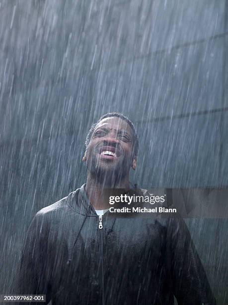 young man standing in rain, head back, looking up - skyfall bildbanksfoton och bilder