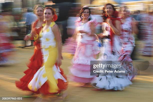 spain, andalucia, seville, flamenco dancers walking (blurred motion) - seville celebrates the feria de abril stock pictures, royalty-free photos & images