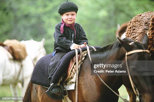 argentina, boy (6-8) on horseback at gaucho festival - gaucho festival stock pictures, royalty-free photos & images