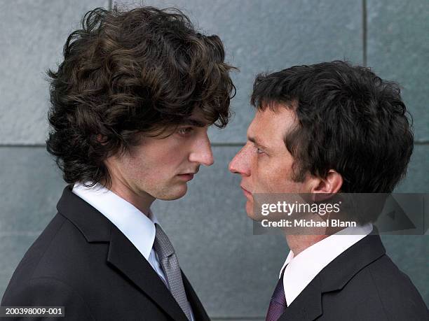 two businessmen face to face, profile, close-up - gestalt stock-fotos und bilder
