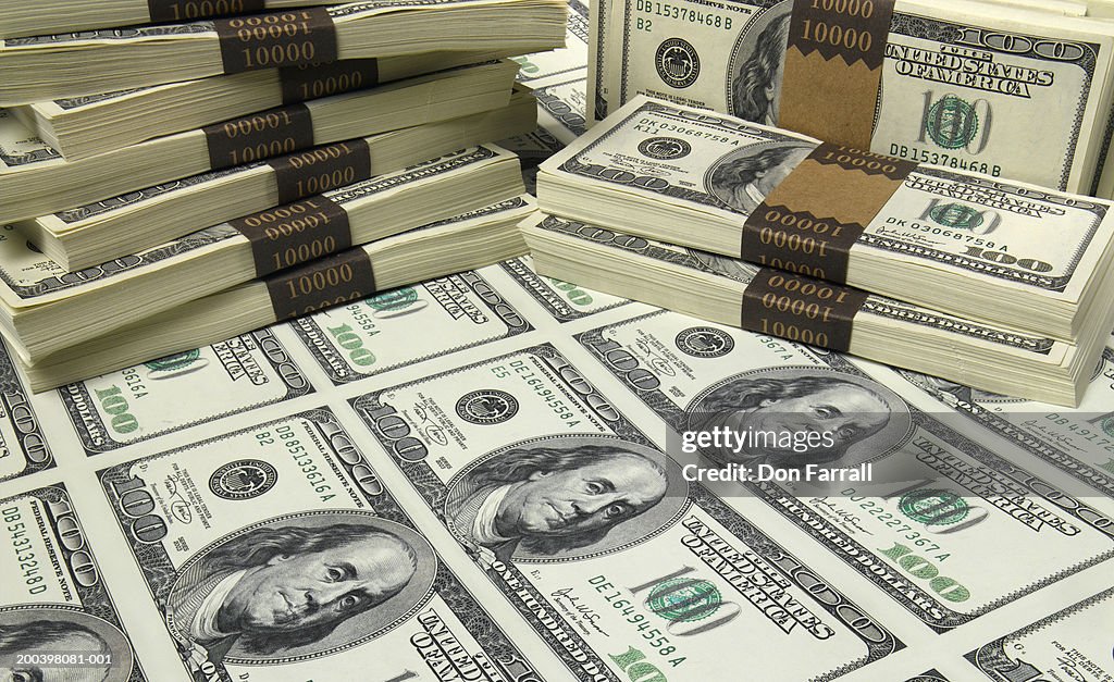 Stacks and sheet of US one hundred dollar bills, elevated view