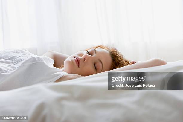 young woman lying in bed - woman sleep bedroom foto e immagini stock