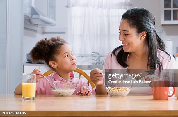 mother and daughter (4-6) at table eating cereal - cereal do café da manhã - fotografias e filmes do acervo