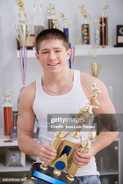 teenage boy (15-17) holding trophy, smiling, portrait - trophy shelf stock pictures, royalty-free photos & images