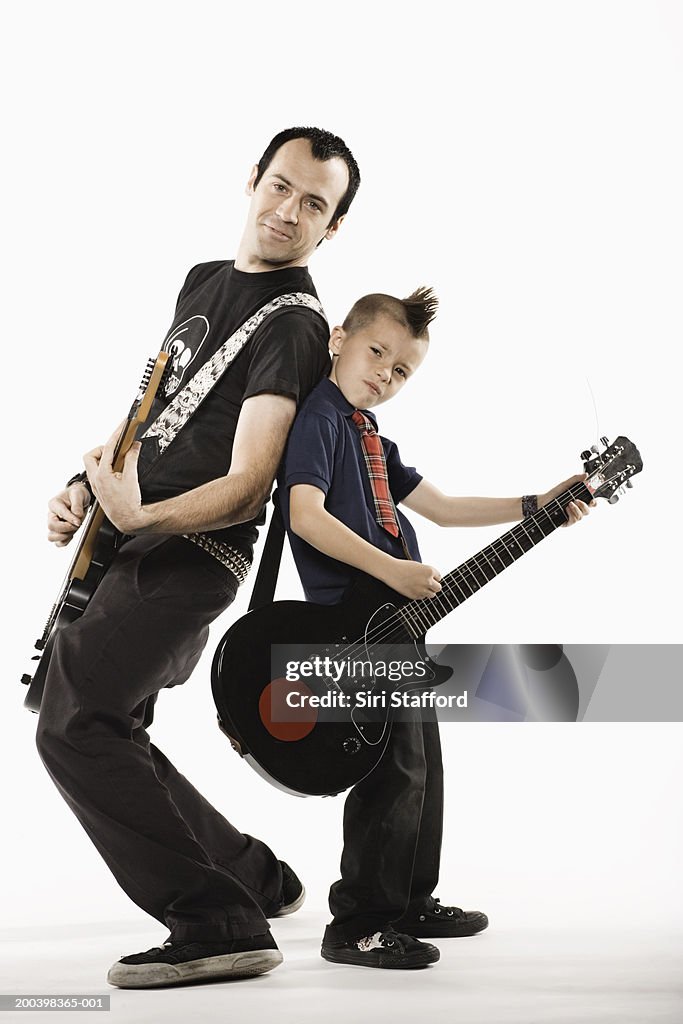 Father and son (8-10) playing guitars