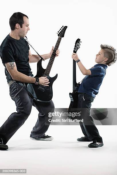 father and son (8-10) playing guitars - spiked belt stock pictures, royalty-free photos & images