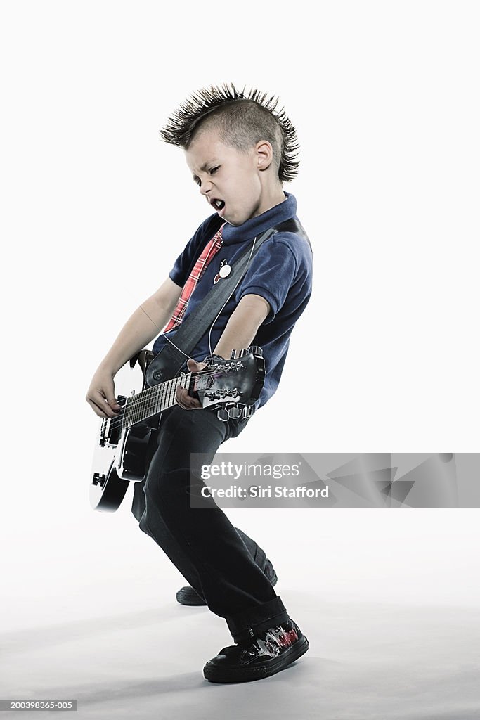 Boy (8-10) playing guitar