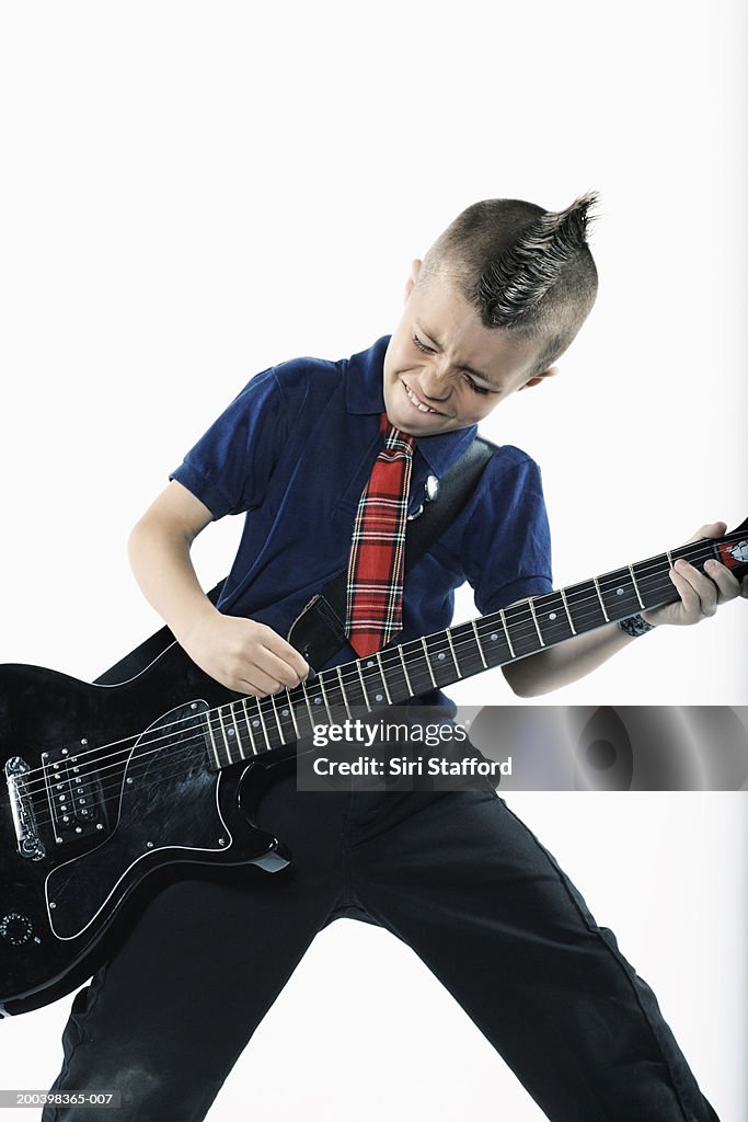 Boy (8-10) playing guitar