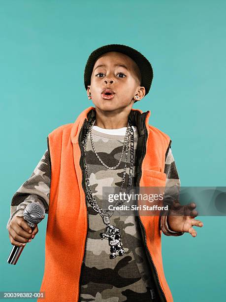 boy (4-6) holding microphone - boy singing stock-fotos und bilder