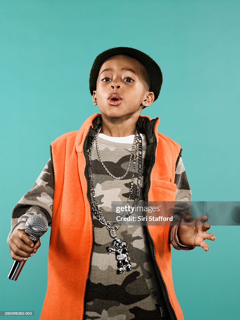 Boy (4-6) holding microphone