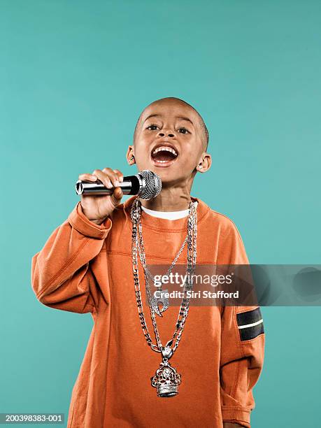 boy (4-6) singing on microphone - boy singing stock-fotos und bilder