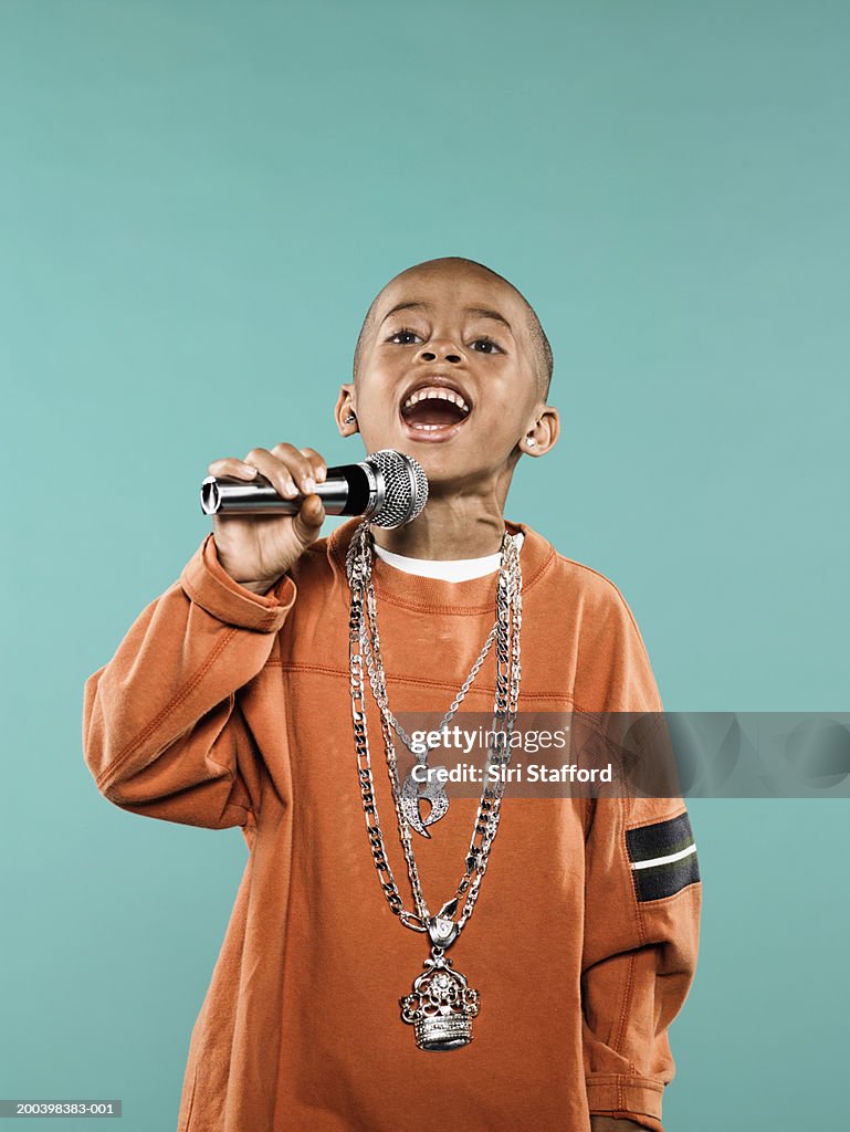 Boy (4-6) singing on microphone