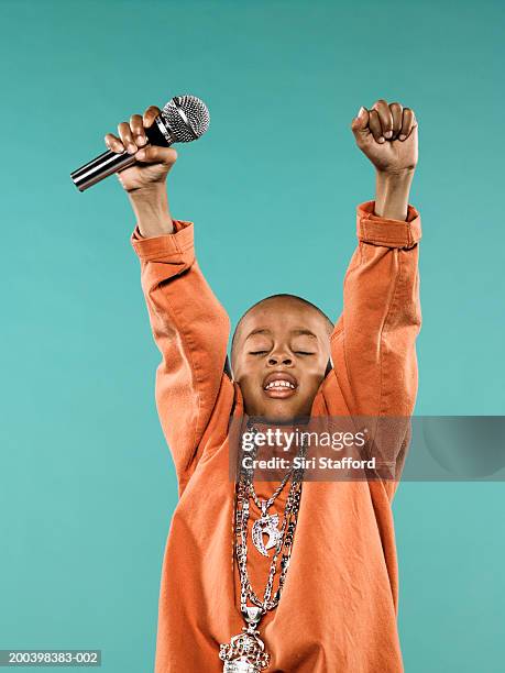 boy (4-6) holding microphone over head - rap singer stock pictures, royalty-free photos & images