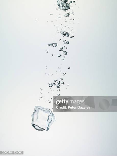 ice cube and bubbles in water - bubble photos et images de collection