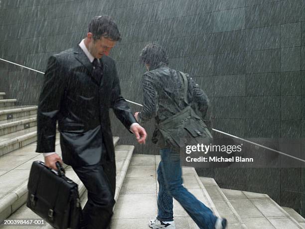 two men passing on steps in rain, side view - drenched stock pictures, royalty-free photos & images
