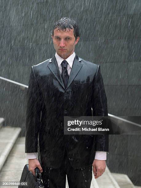 businessman with briefcase standing on steps in rain, portrait - saturated color stock pictures, royalty-free photos & images