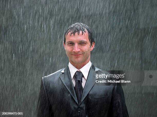 businessman standing in rain, smiling, portrait, close-up - wet stock pictures, royalty-free photos & images