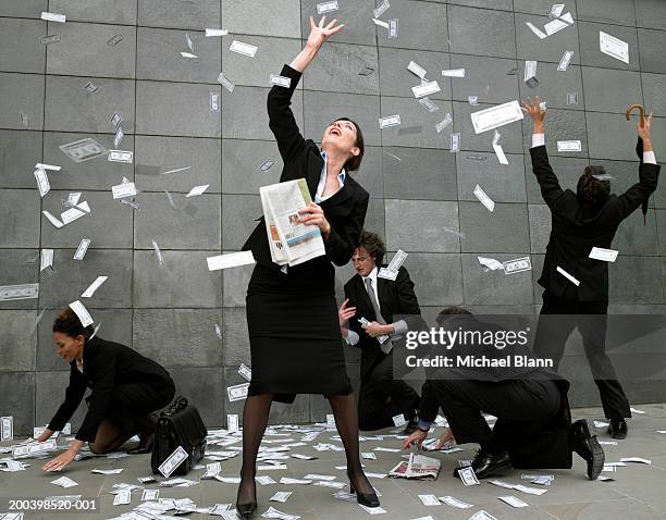 business people on pavement catching falling money - greed fotografías e imágenes de stock