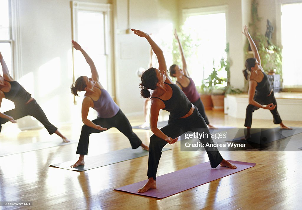 Group of women stretching in yoga class, arms raised