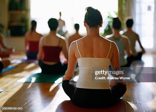 group of people sitting in lotus position in yoga class, rear view - tank top back stock pictures, royalty-free photos & images