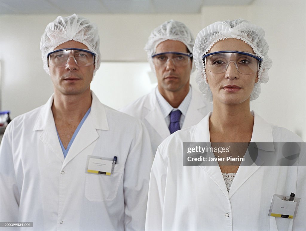 Woman and two men wearing lab coats and glasses, portrait