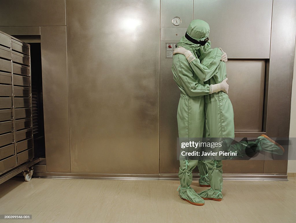 Man and woman wearing boiler suits embracing
