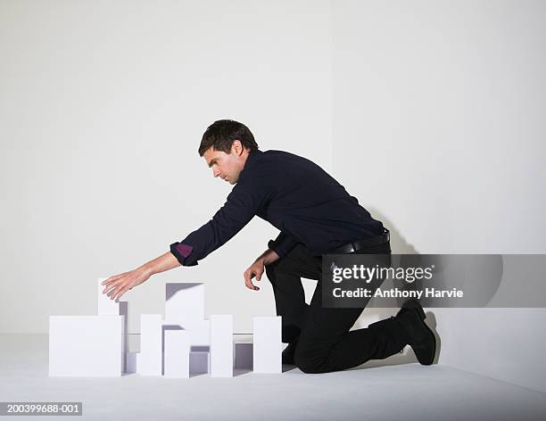 man building blocks, side view - kneeling stock pictures, royalty-free photos & images