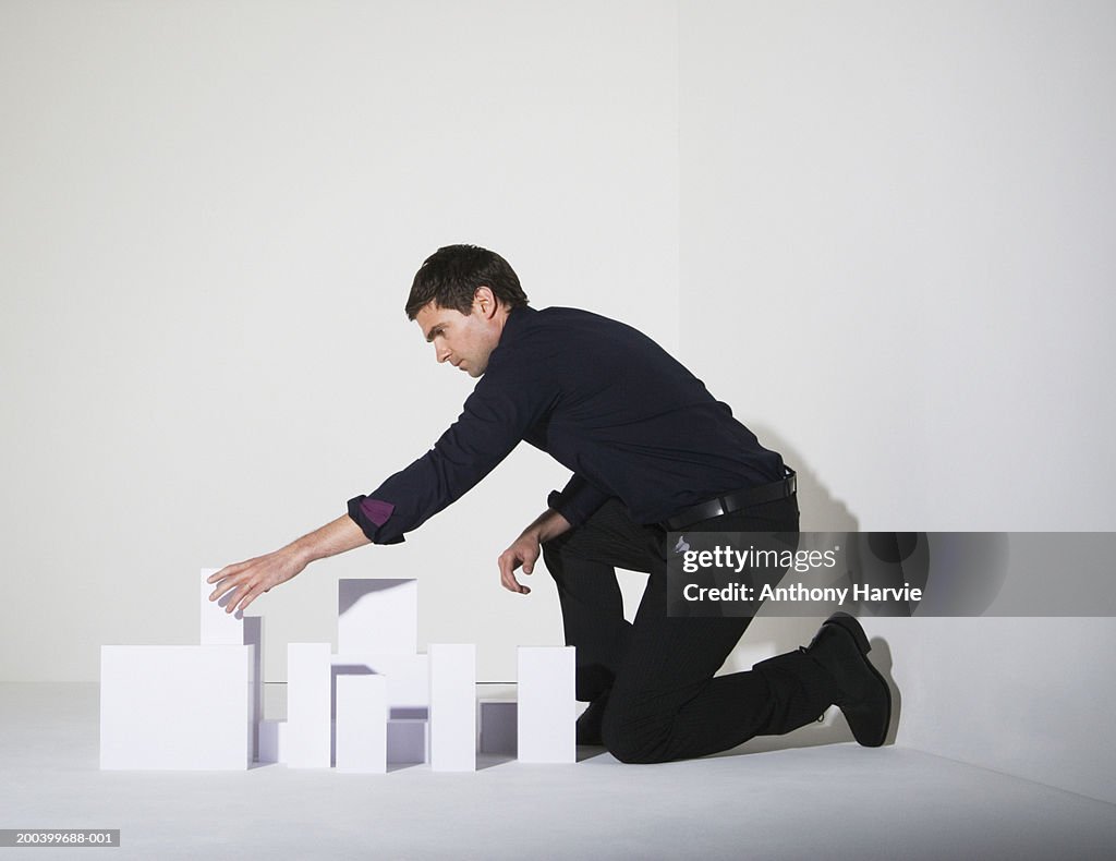 Man building blocks, side view
