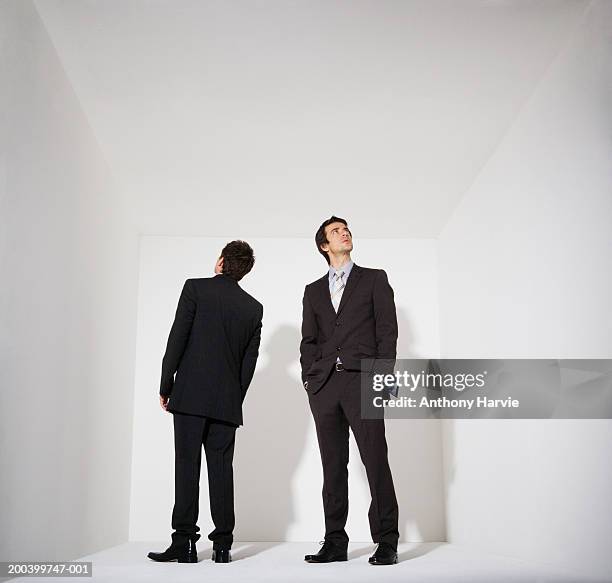 two businessmen standing in white room - two people white background stock pictures, royalty-free photos & images