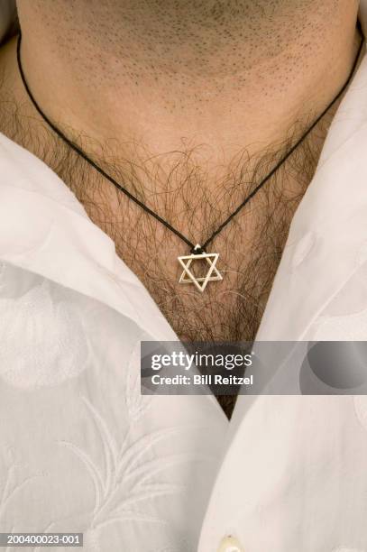 man wearing star of david pendant on leather necklace, mid section - hairy chest stock-fotos und bilder