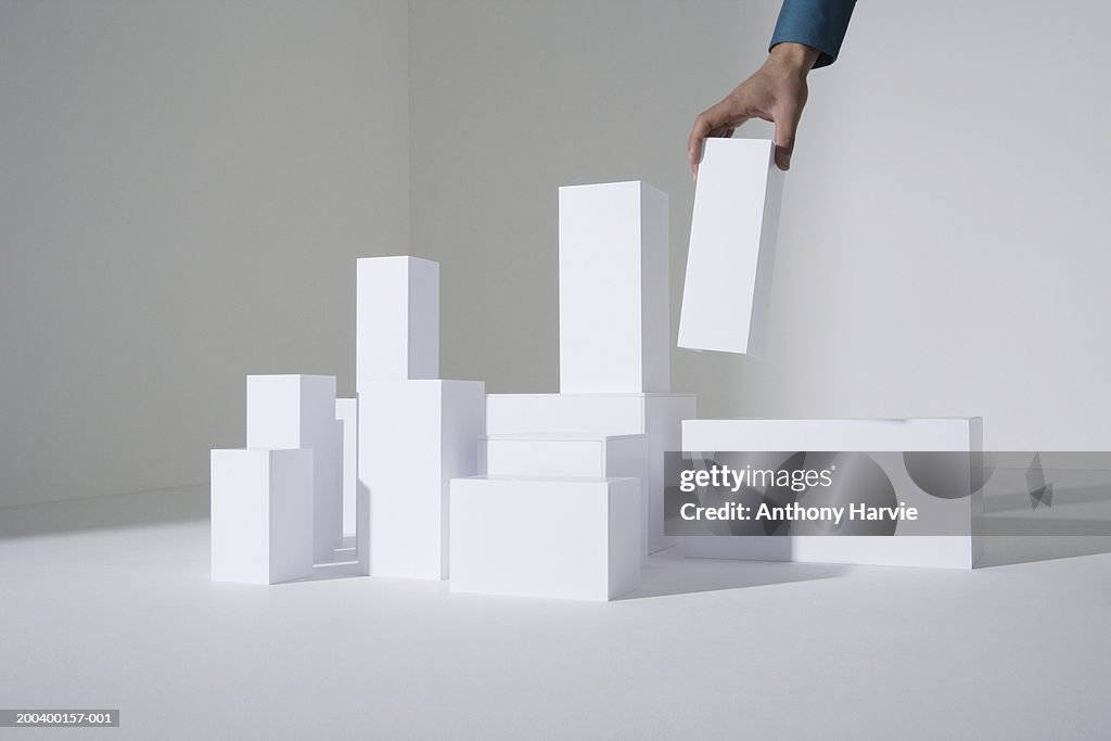 Man building white blocks, close-up