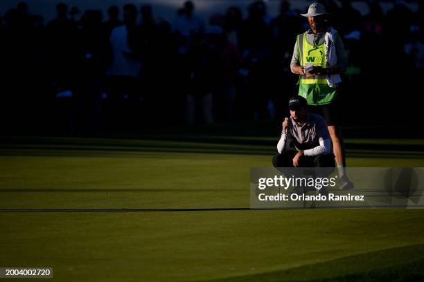 Nick Taylor of Canada and caddie Dave Markle line up a putt on the 18th green during the final round of the WM Phoenix Open at TPC Scottsdale on...