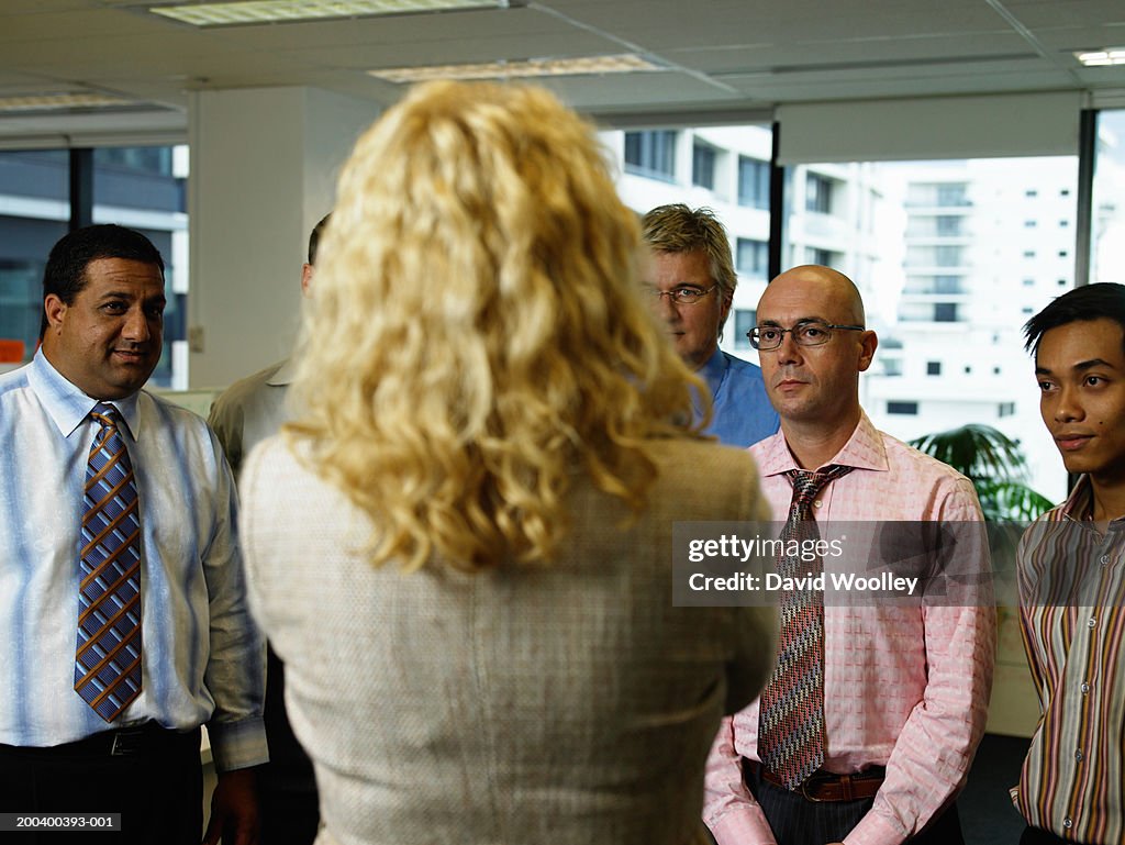 Businesswoman standing in front of male colleagues