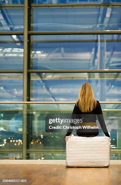 woman sitting in airport, rear view - woman blond looking left window photos et images de collection