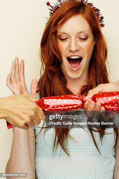 cracker being pulled in front of woman, shocked expression on face - pulling cracker stock pictures, royalty-free photos & images